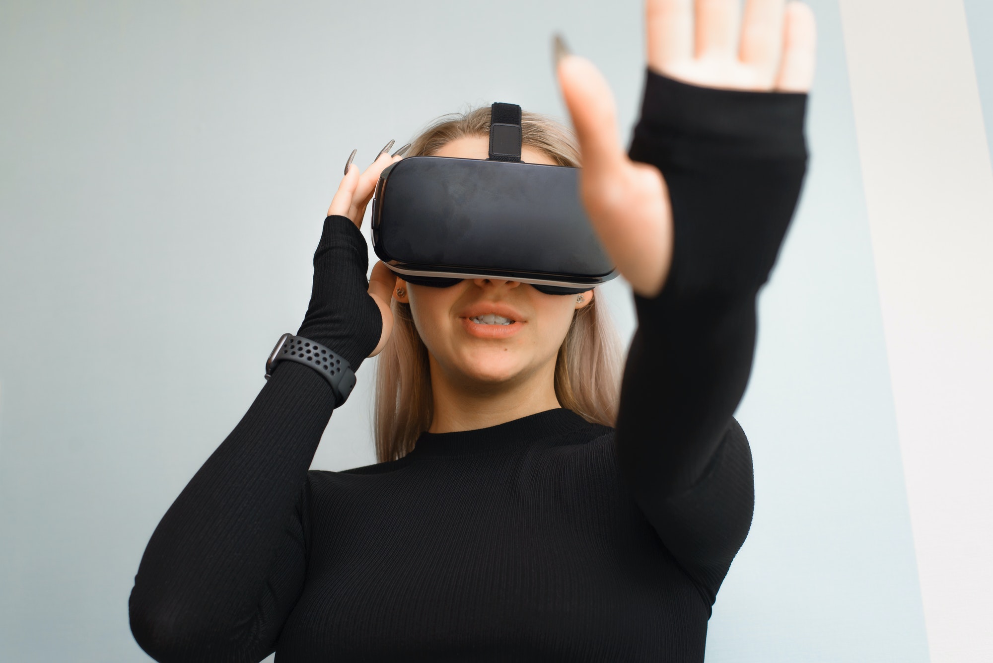 Young woman wearing virtual reality glasses, VR. A girl using the technology of the future, indoors